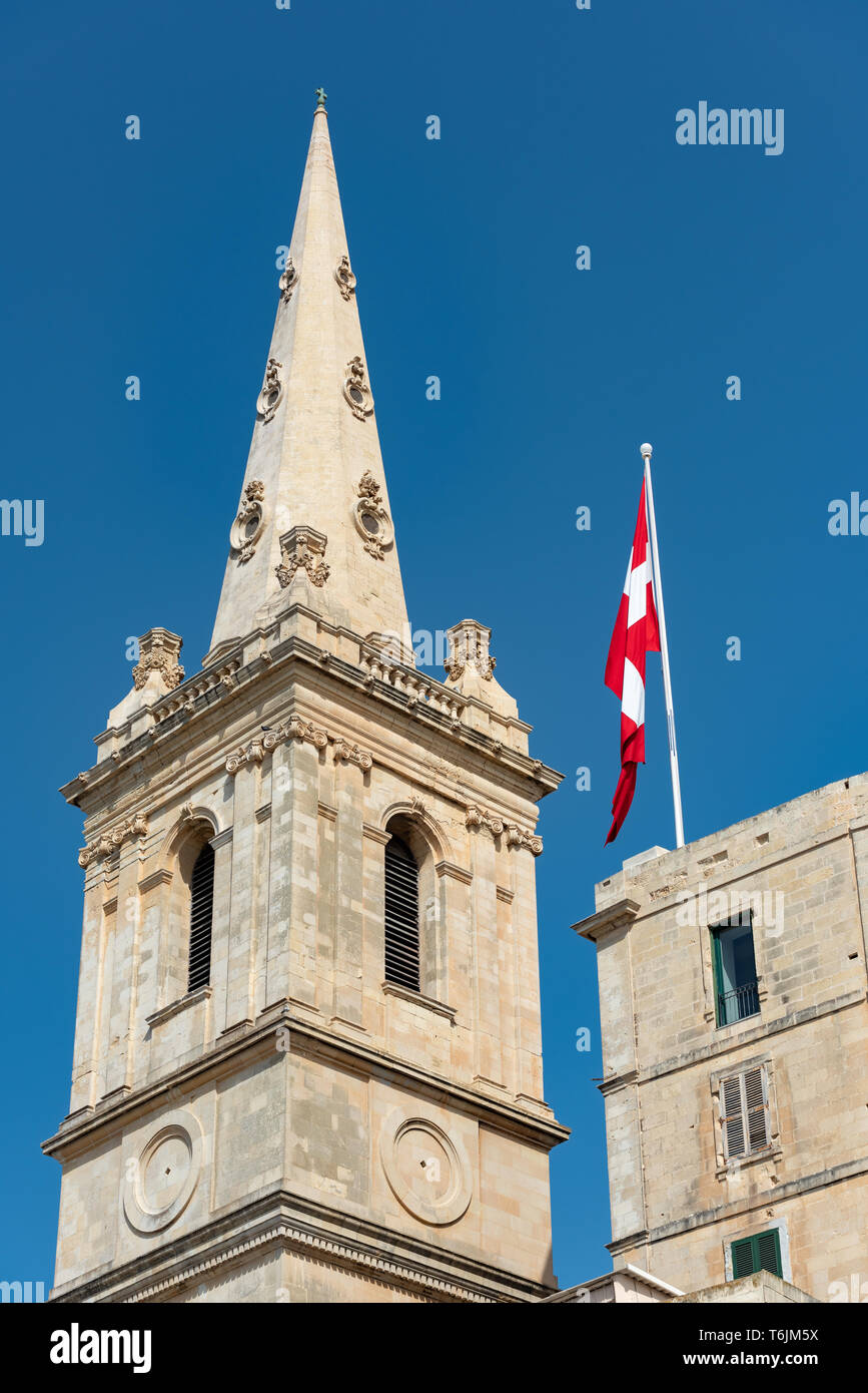 The 60m tall steeple of St Paul's Pro-Cathedral in Valletta with a Maltese Flag Stock Photo