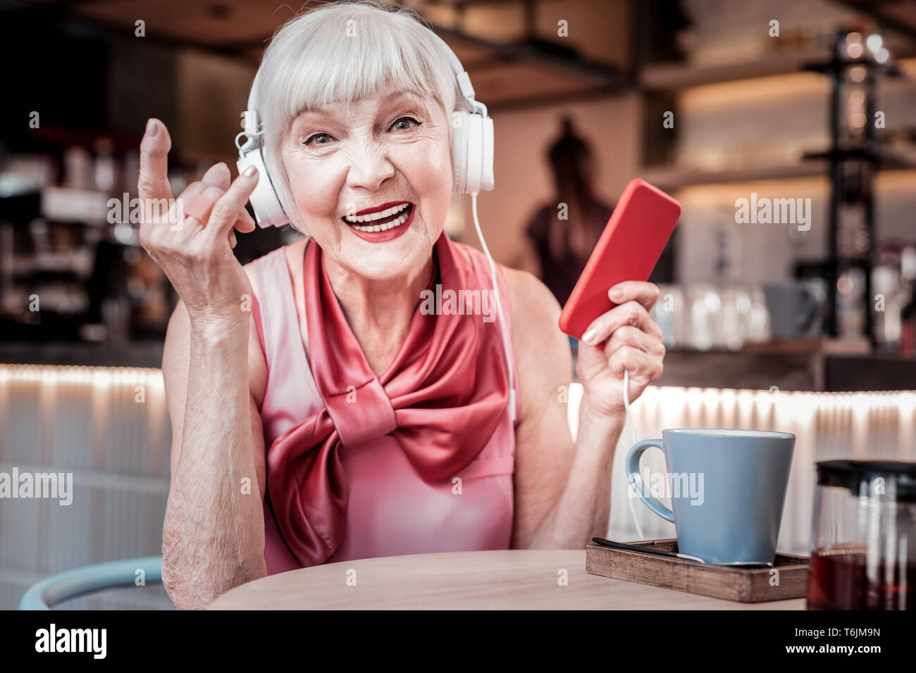 Amused short-haired old woman wearing bright silk top Stock Photo