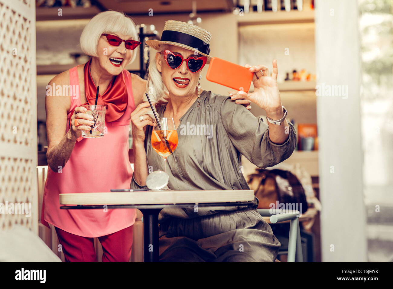 Resolute cheerful senior women wearing bright stylish outfits Stock Photo