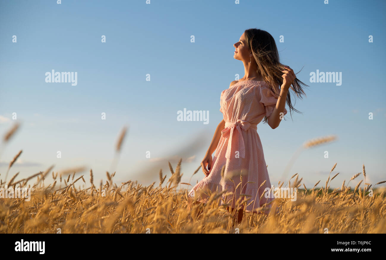 Young woman in wheat field at sunset Stock Photo - Alamy