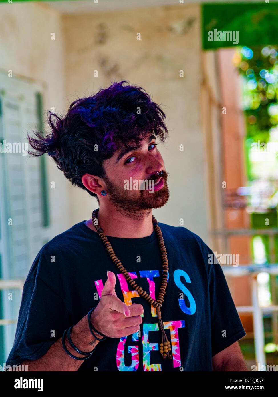 tousled boy with necklace and black pullover with letters Stock Photo