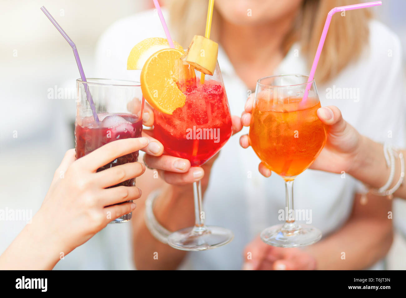 Cheers with different colored cocktails, red spritz, blueberry and orange spritz. Stock Photo