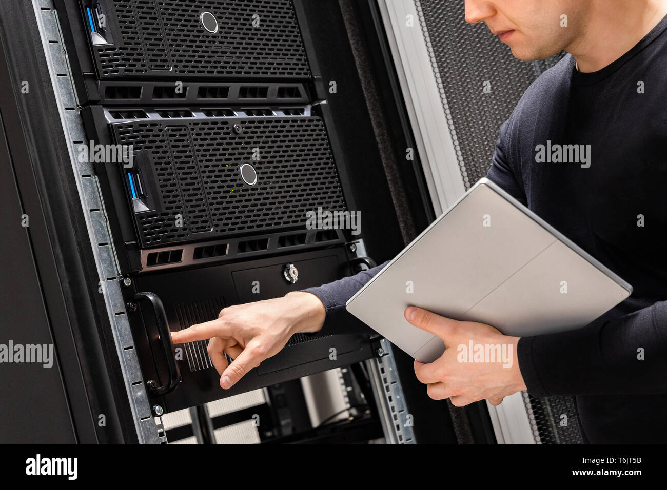 IT Support Holding Digital Tablet Examining and Perform Service on Servers Stock Photo