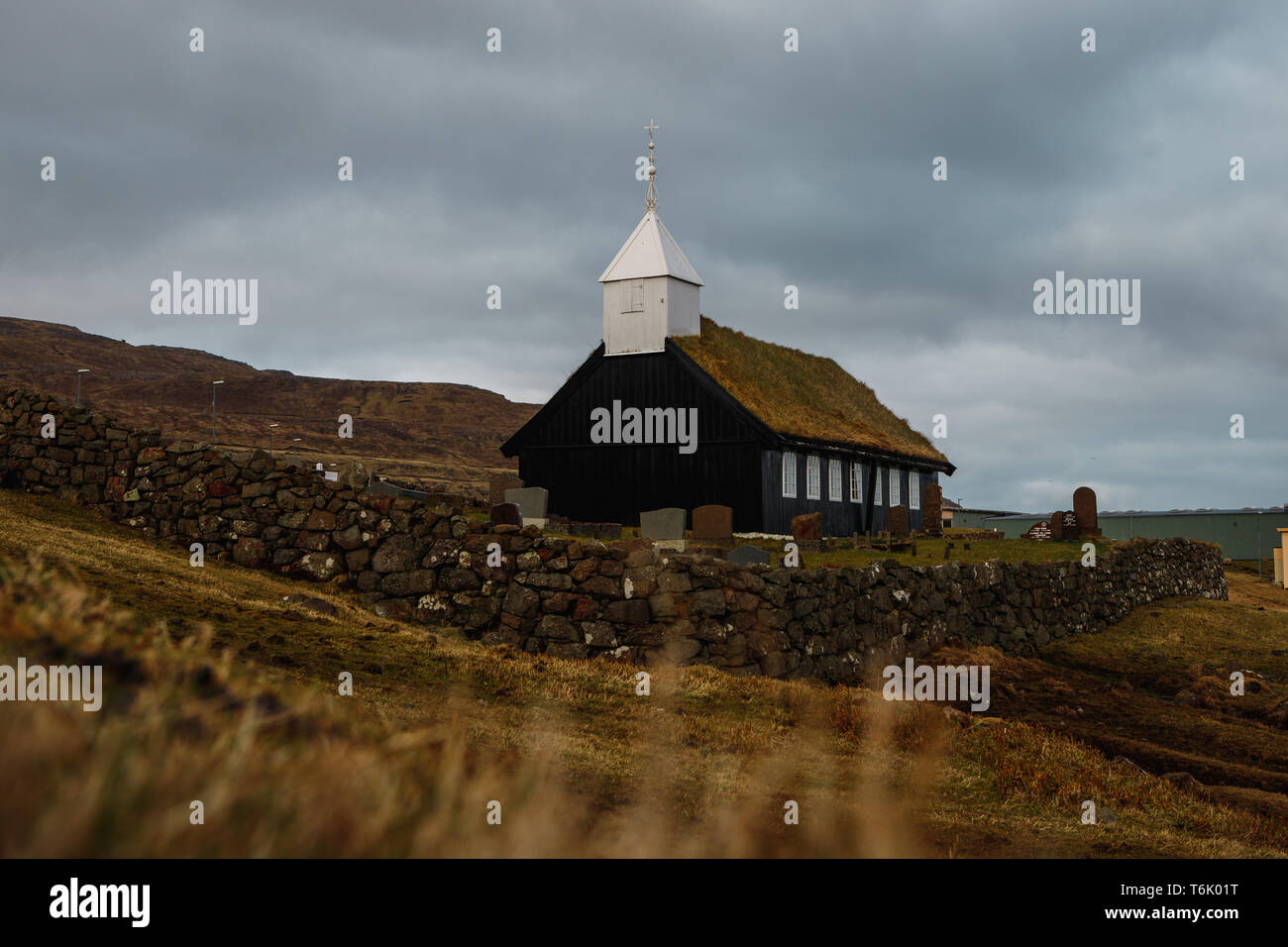 Black wooden church of Kaldbak (Kaldbak Kirkja) during a moody evening with dramatic sky on Streymoy island (Faroe Islands, Denmark, Europe) Stock Photo