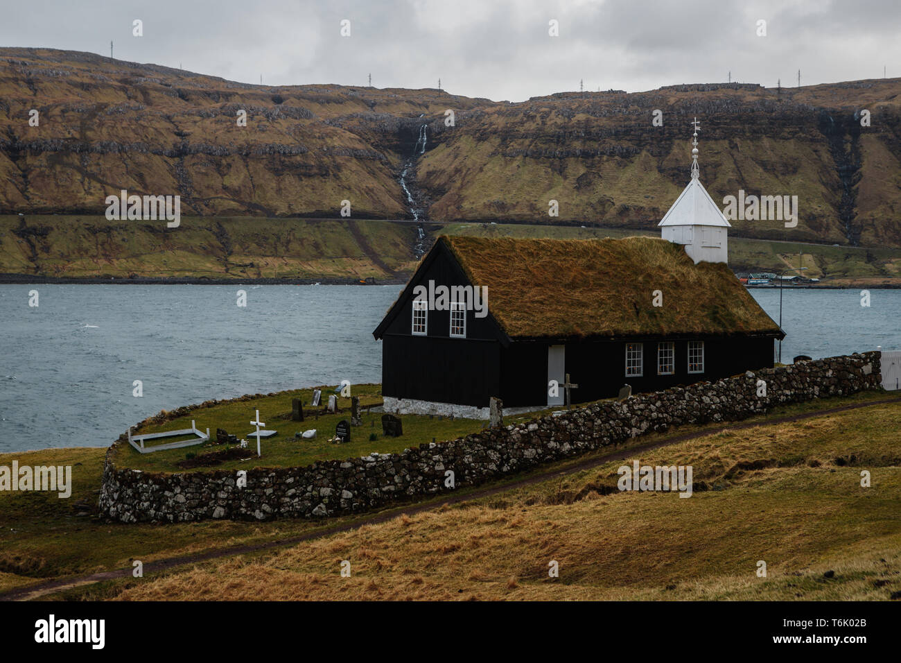 Black wooden church of Kaldbak (Kaldbak Kirkja) during a moody evening with dramatic sky on Streymoy island (Faroe Islands, Denmark, Europe) Stock Photo