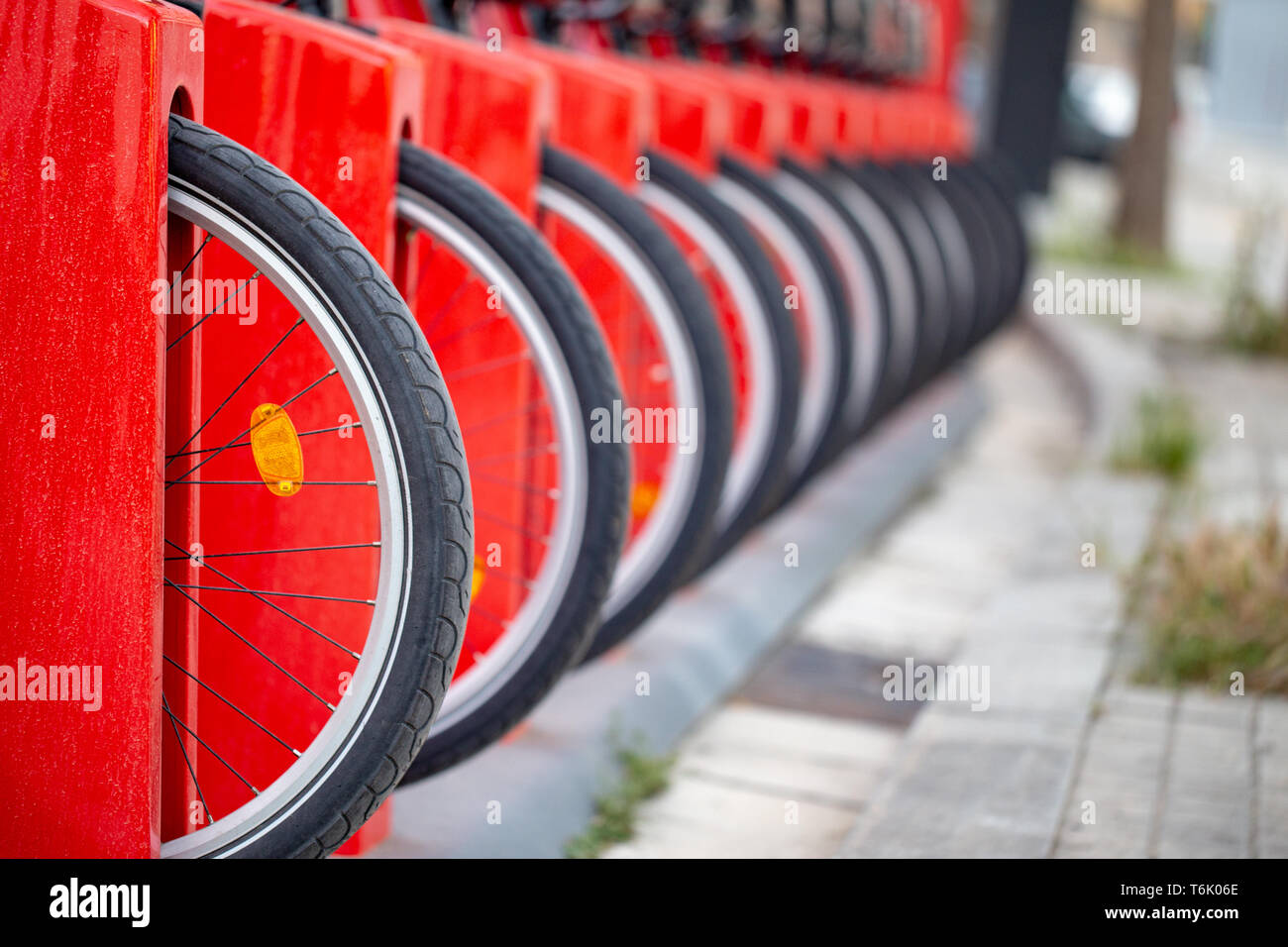 Many bicycle in a row. Red bicycles stand on a parking for rent. Eco friendly transportation concept. Stock Photo