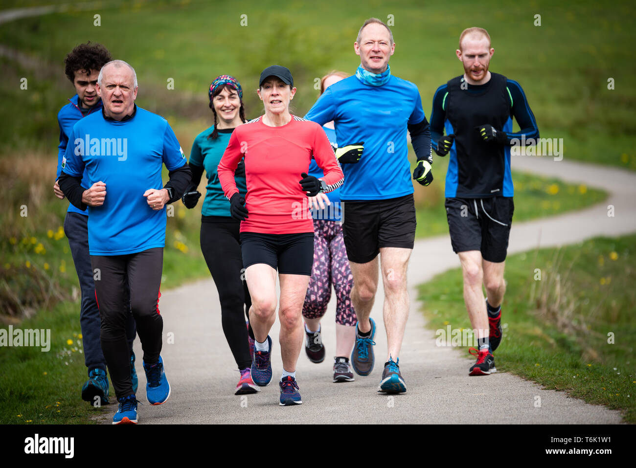 Group of people of mixed ages running together outside, preparing for the marathon Stock Photo