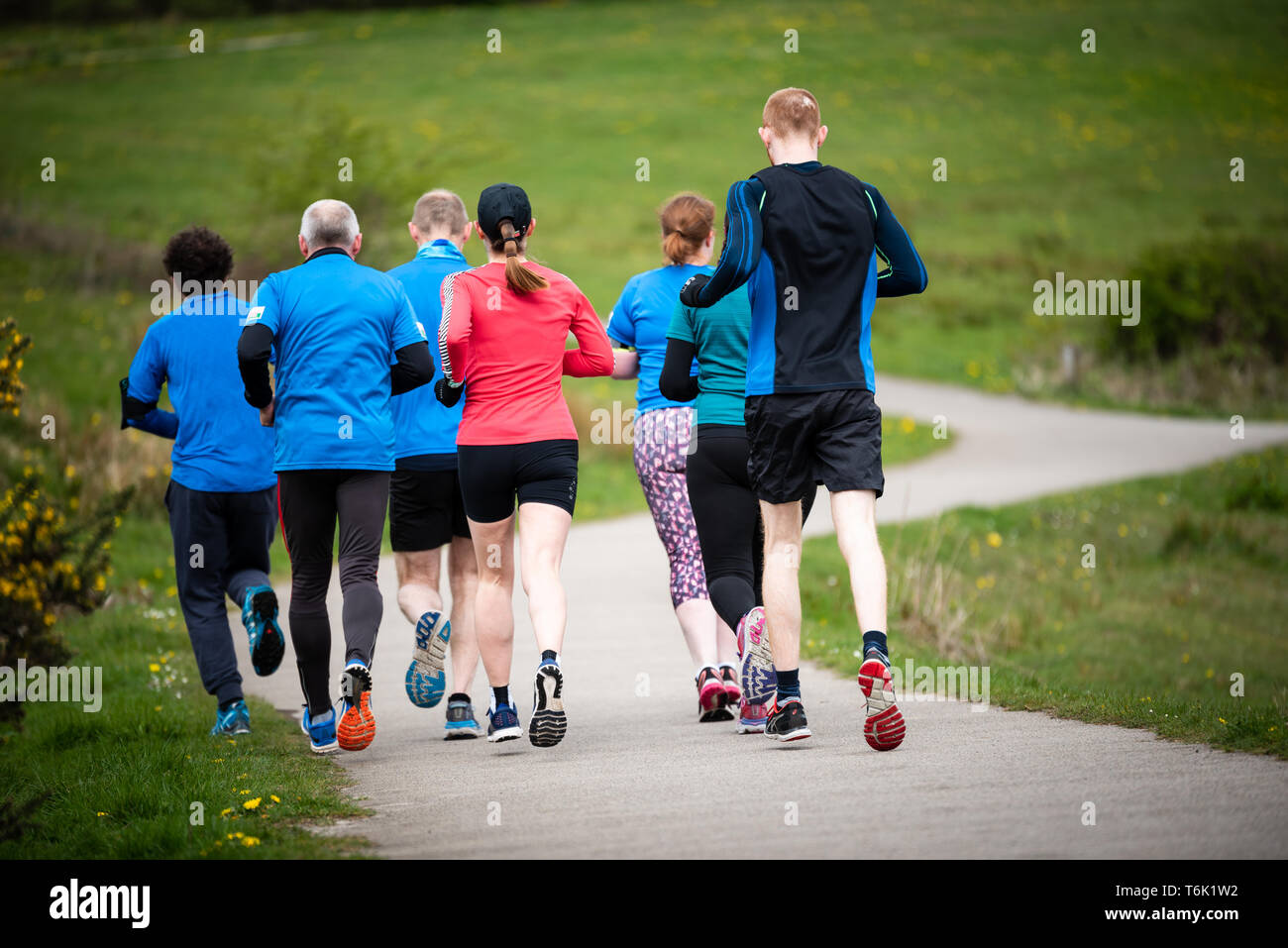 Group of people of mixed ages running together outside, preparing for the marathon Stock Photo