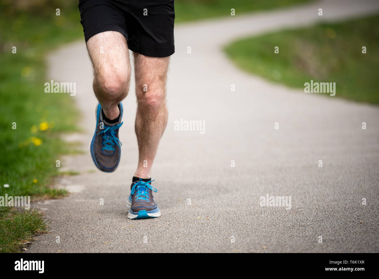 Senior man in 50s exercising and keeping fit by running in a park Stock Photo