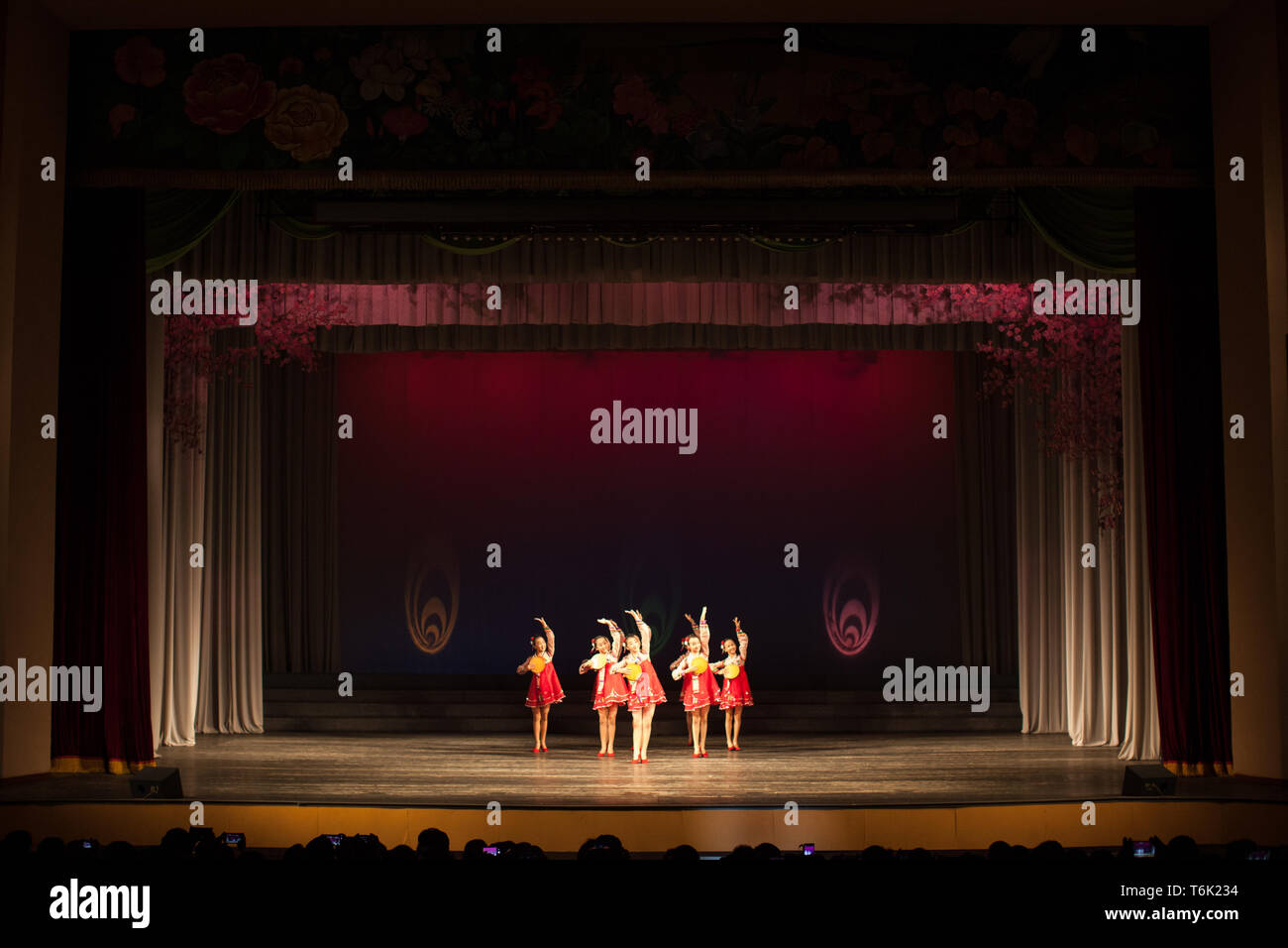North Korean children perform a dance for visitors in a Pyongyang theatre. Stock Photo