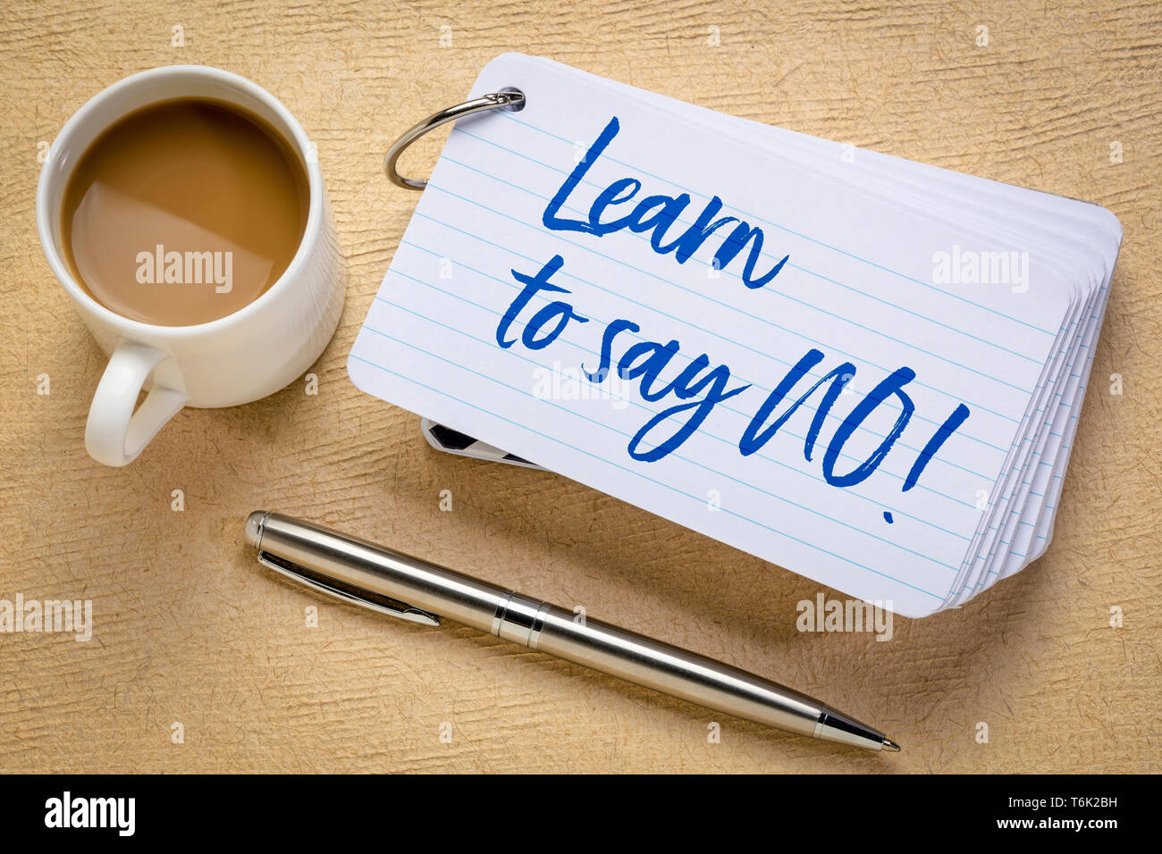 Learn to say no  advice or reminder- handwriting on a stack of index cards with a cup of coffee and a pen against textured bark paper Stock Photo