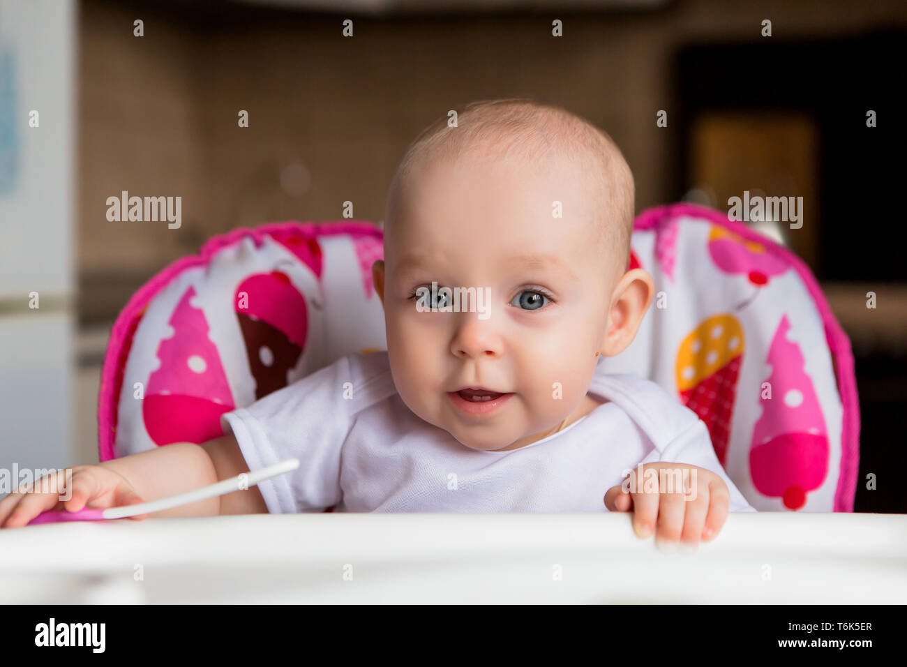 baby in a child seat eating vegetables.baby in the baby chair eating