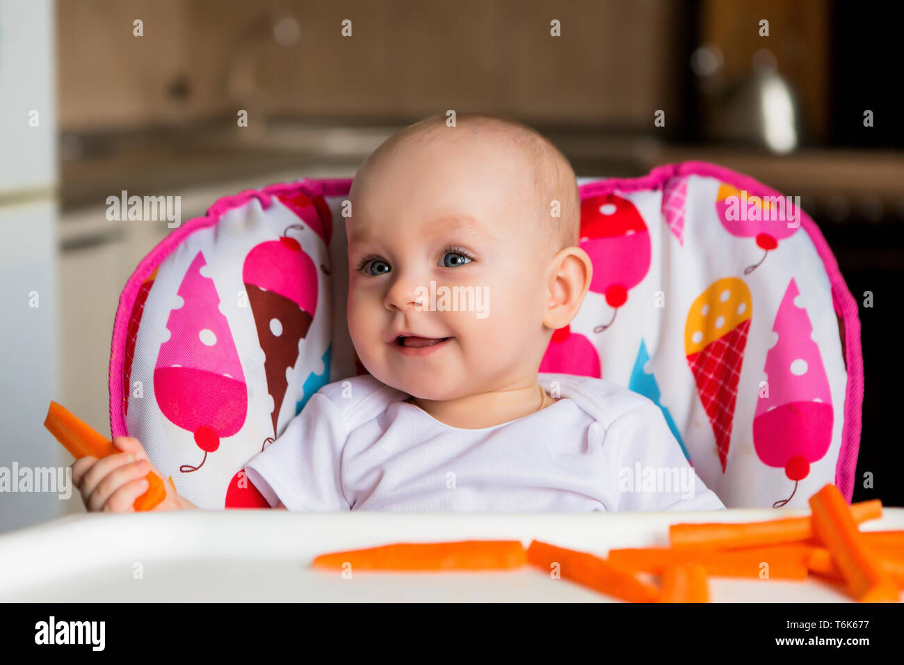 baby in a child seat eating vegetables.baby in the baby chair