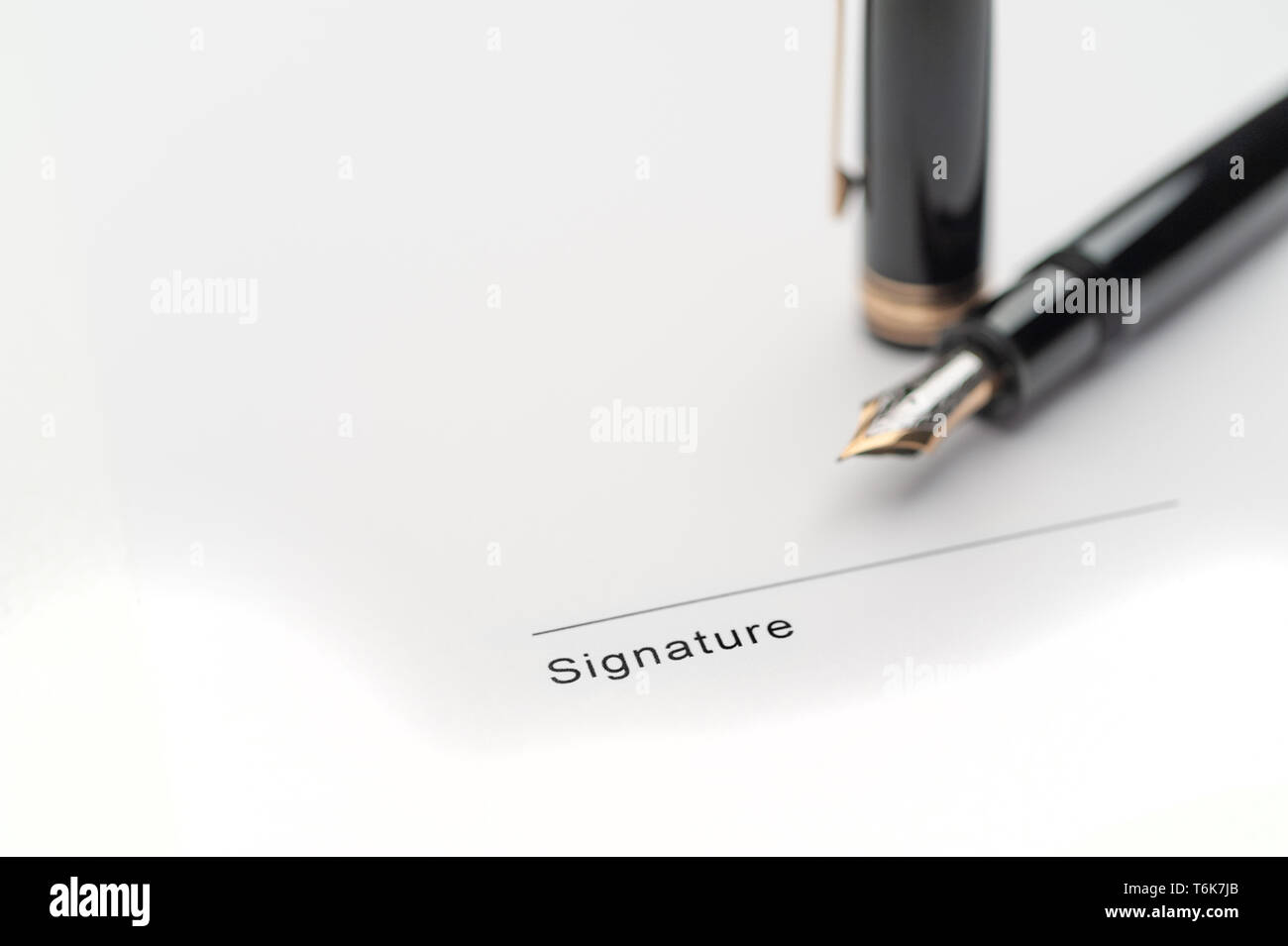 Black fountain pen on document pointing to signing area Stock Photo