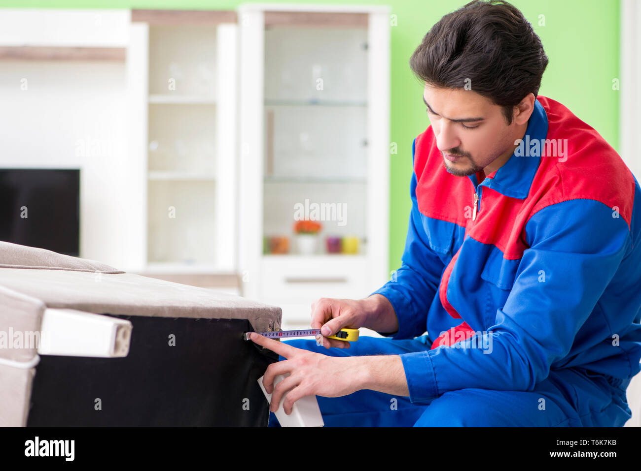 The repair contractor repairing broken furniture at home Stock Photo