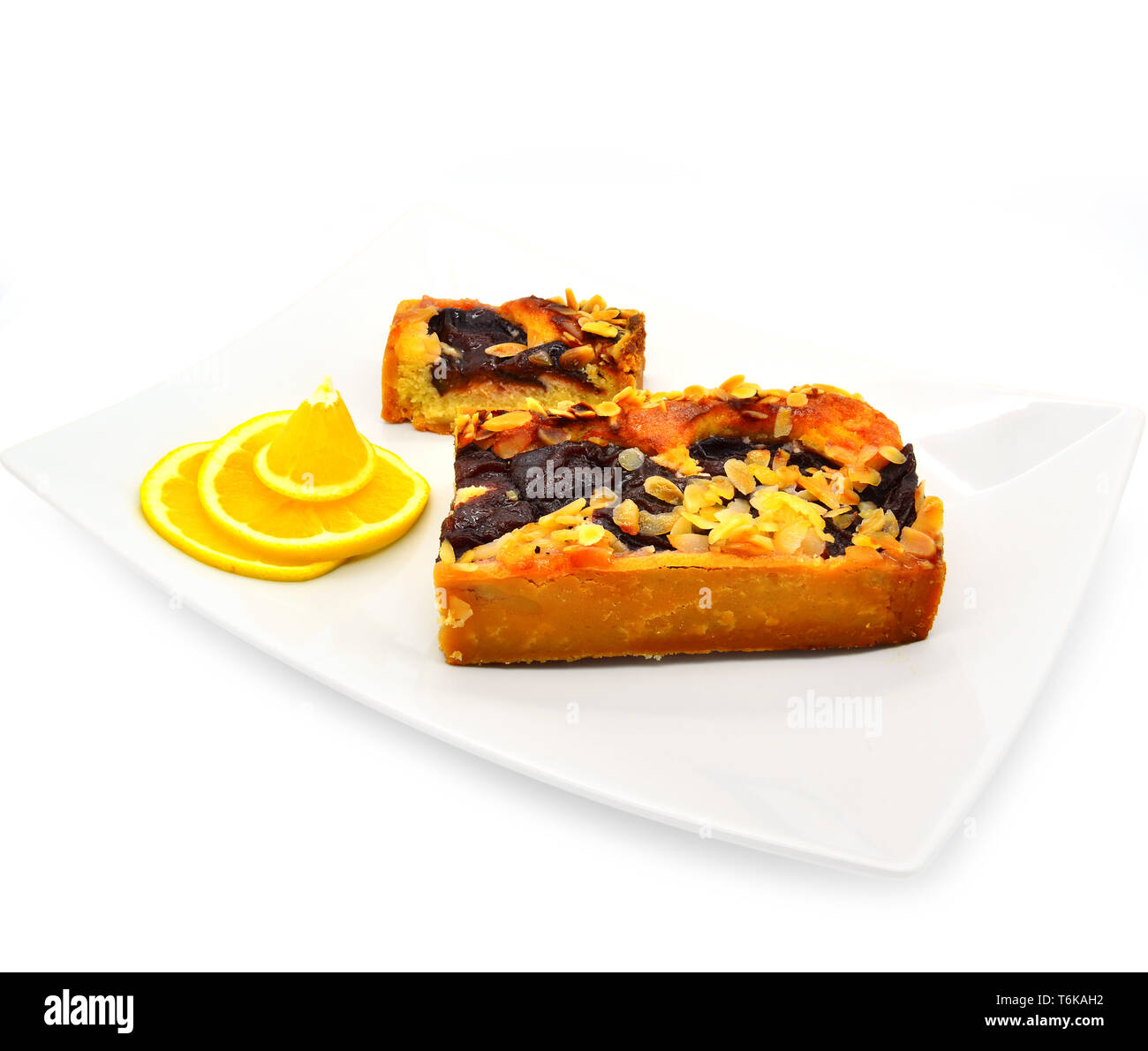 sliced plum pie with almonds on a white background. Stock Photo