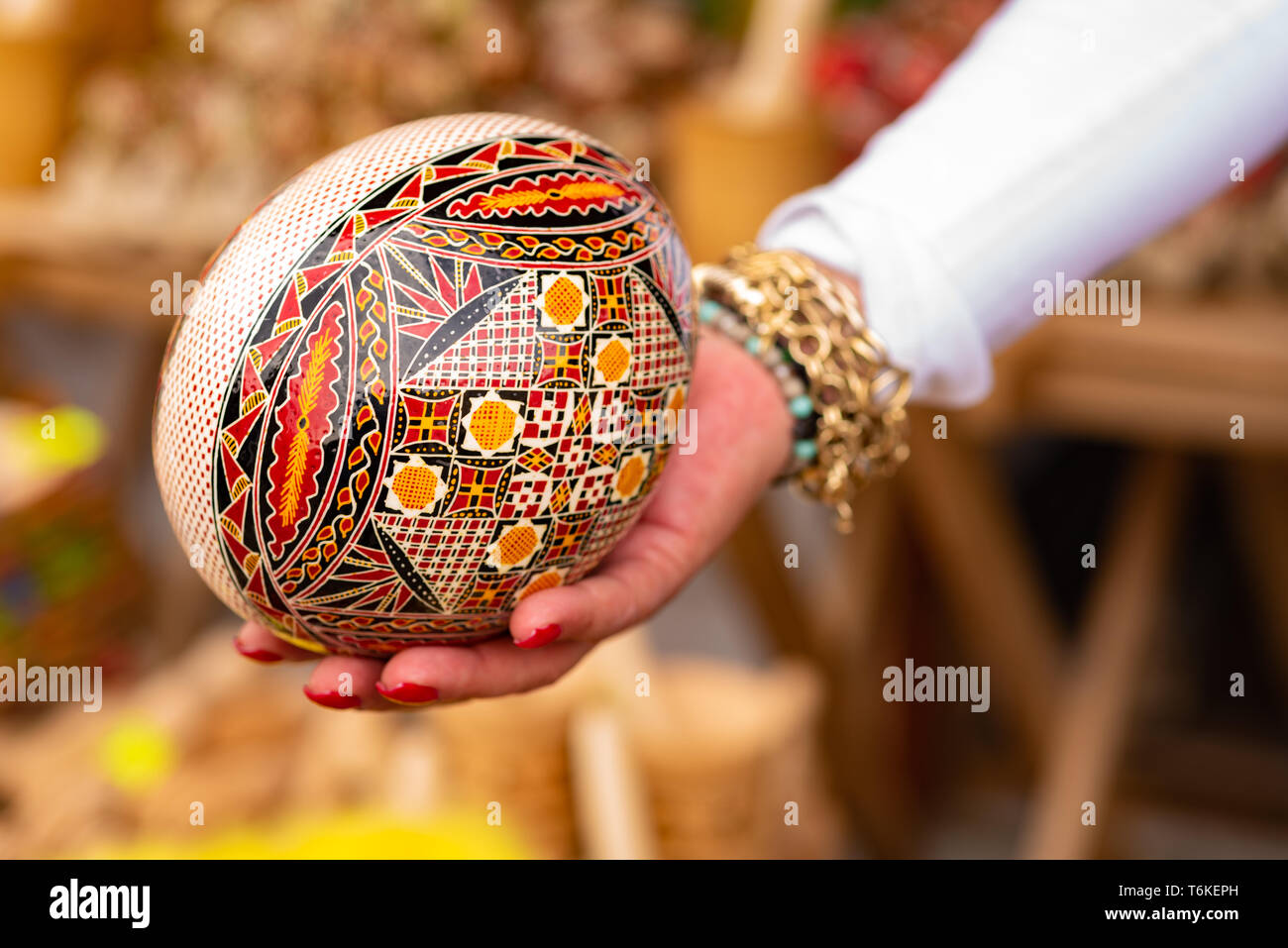 Big wooden painted egg in a hand Stock Photo