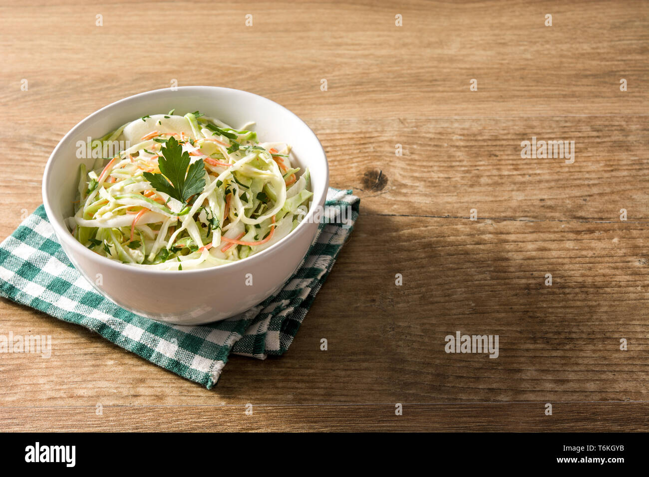 Coleslaw salad in white bowl on wooden table Stock Photo