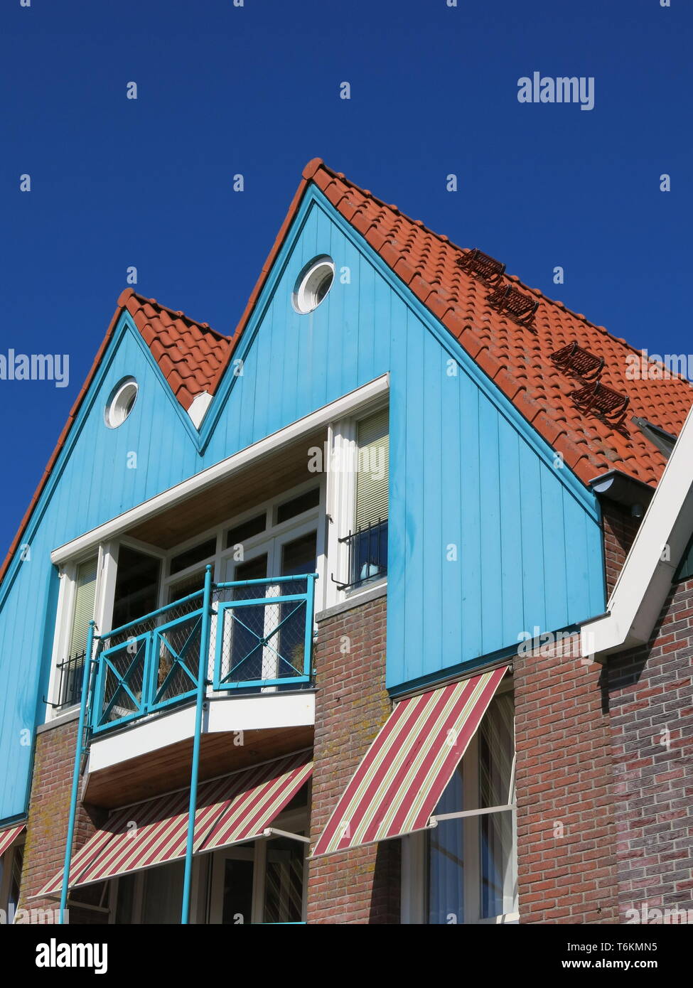 Example of Dutch domestic architecture in the pretty North Holland tourist  town of Volendam; turquoise painted gable end, veranda and striped awning  Stock Photo - Alamy