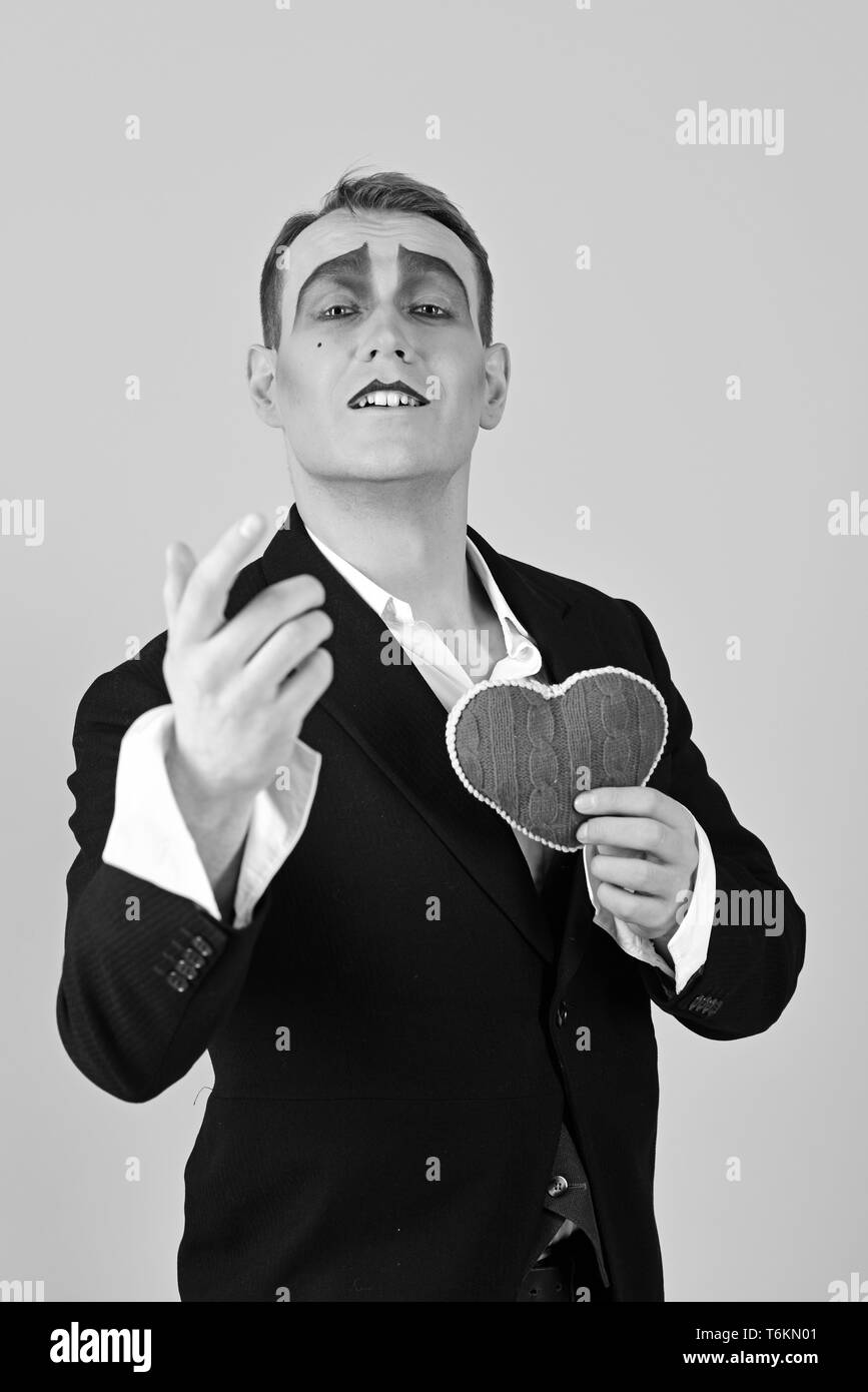 Performing love on stage. Theatre actor pantomime falling in love. Mime man hold red heart for valentines day. Mime actor with love symbol. Love Stock Photo
