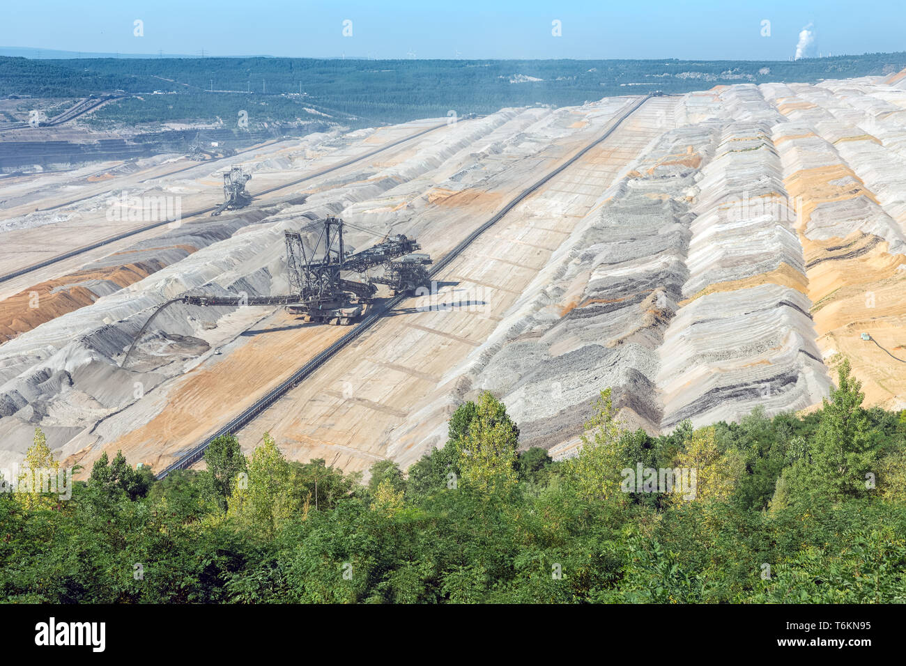 Brown coal open pit landscape with digging excavators in Germany Stock Photo