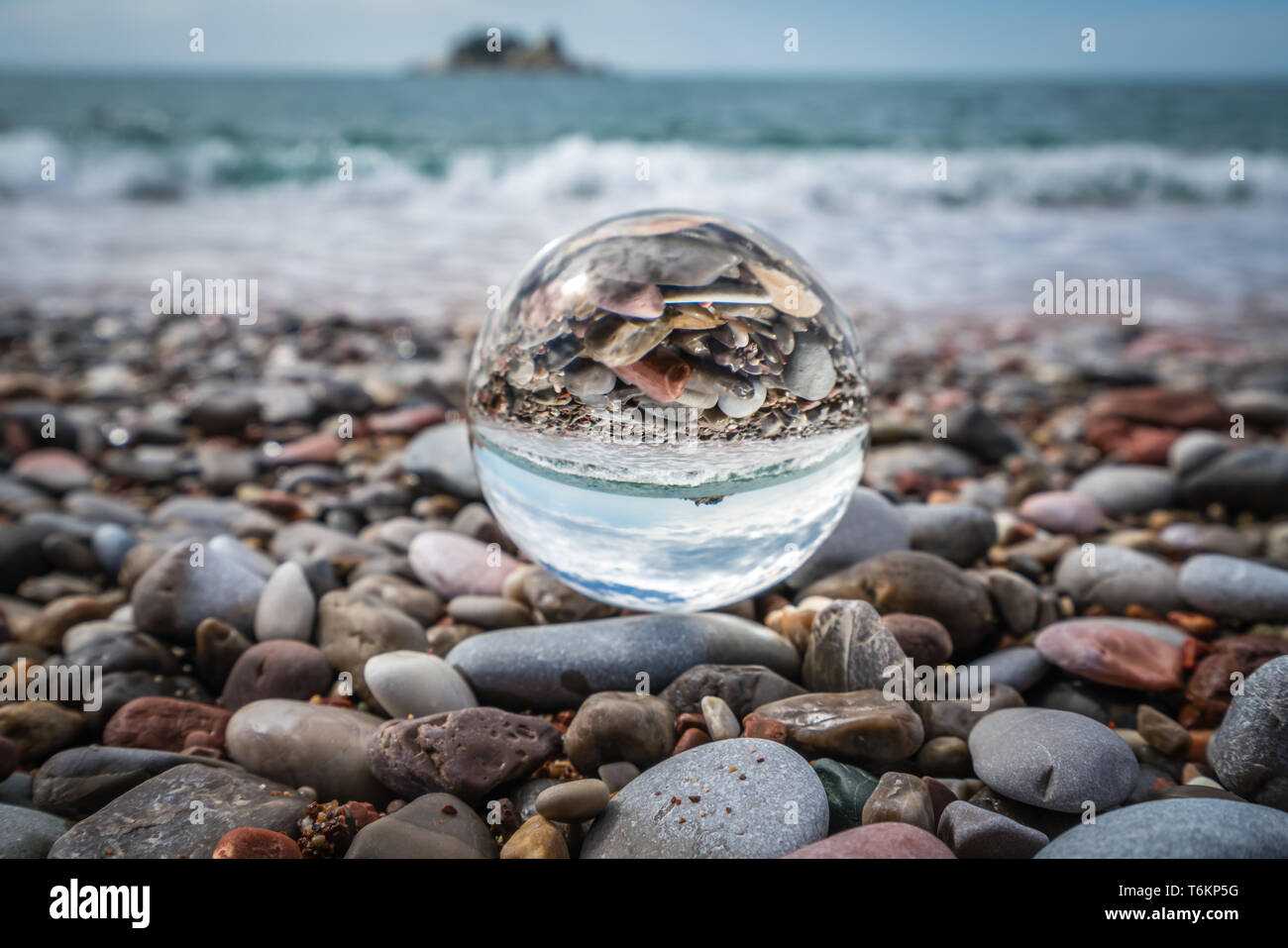 Beach peebles reflected in a galss ball Stock Photo