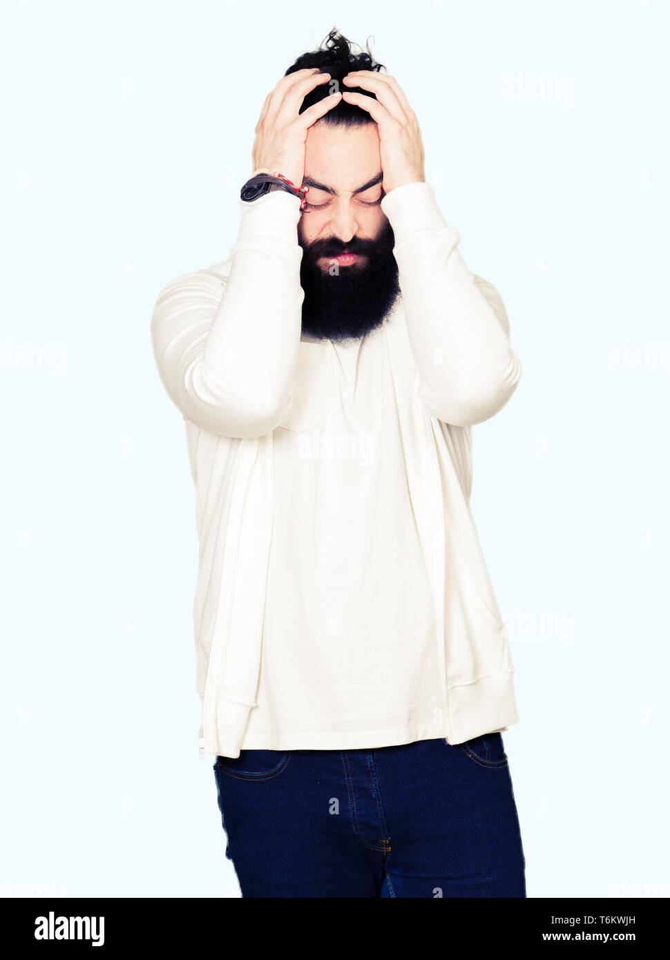 Young man with long hair and beard wearing sporty sweatshirt suffering ...