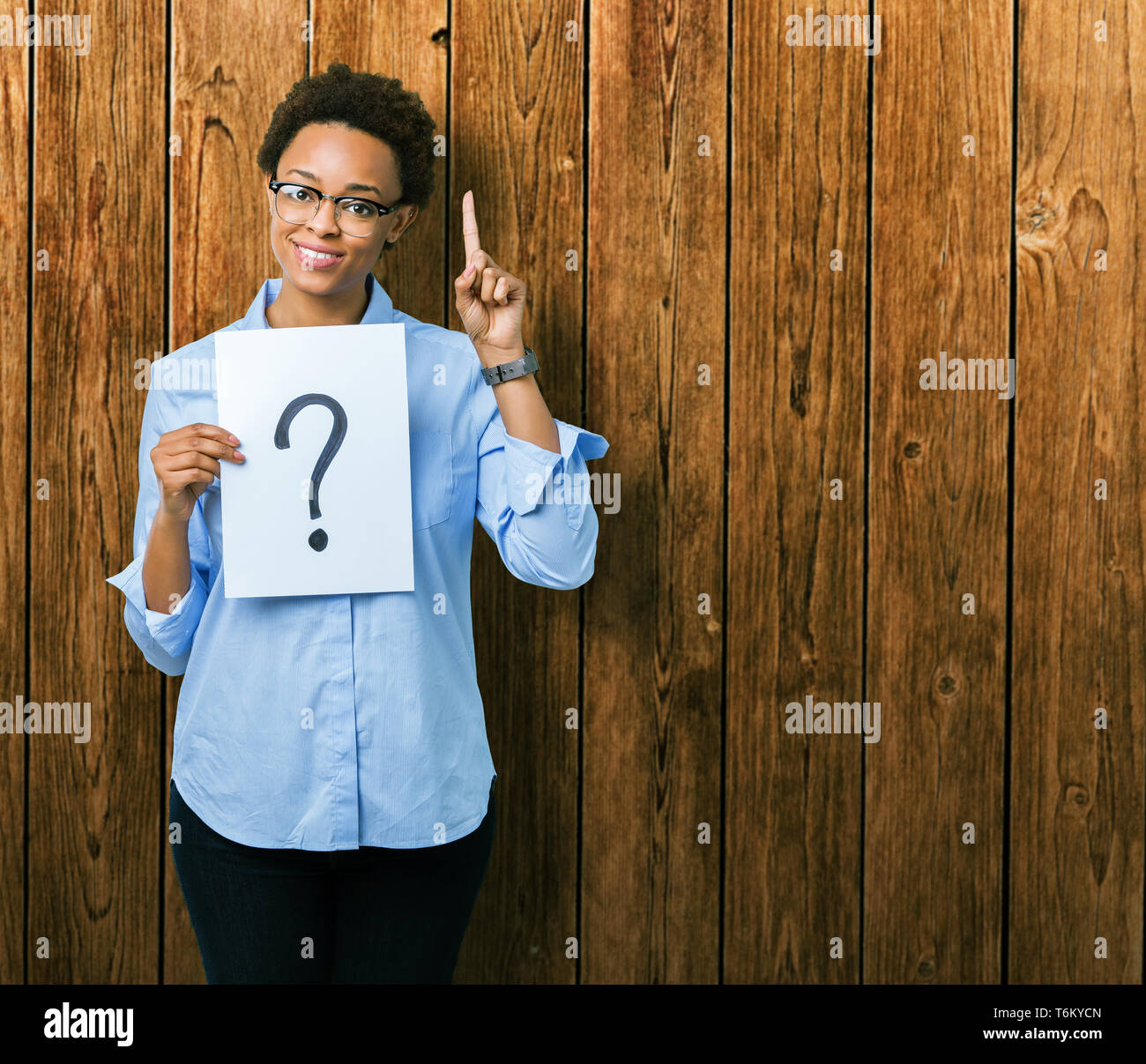 Question Pointing Young african american woman holding paper with question mark over ...