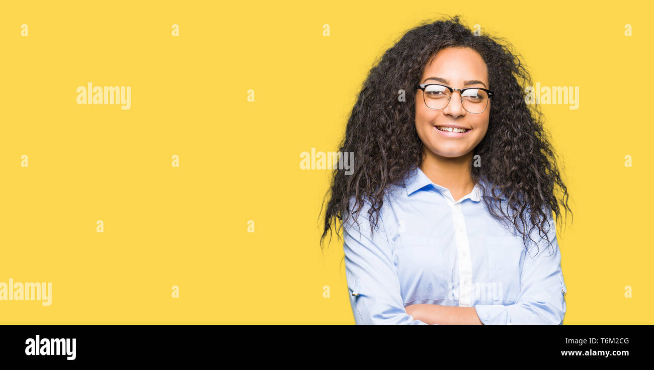 Young beautiful business girl with curly hair wearing glasses happy ...