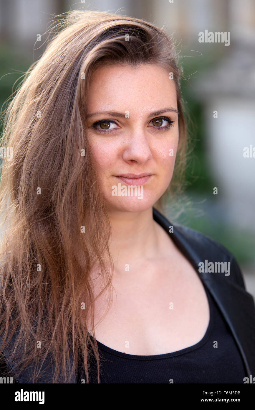portrait of young brunette woman outdoors wearing black leather jacket ...