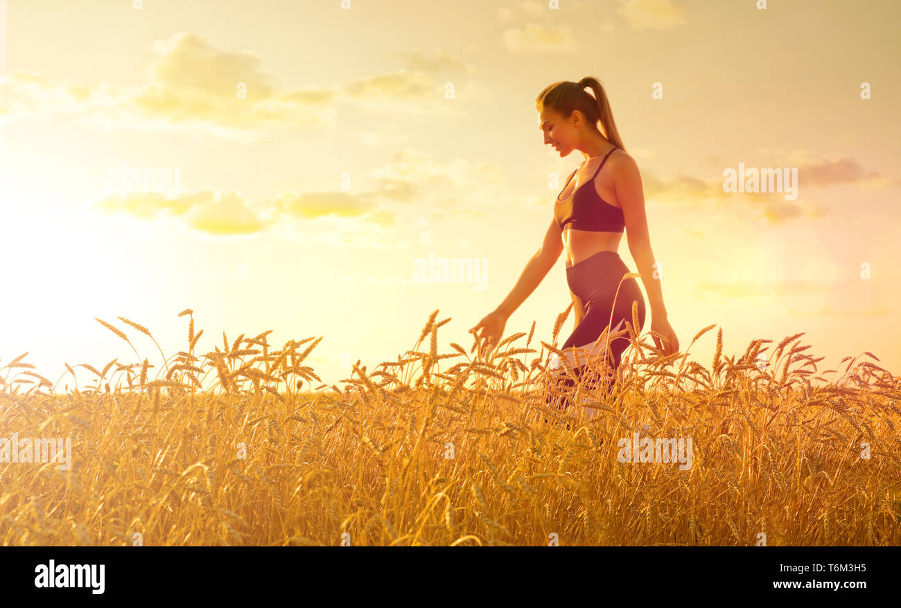 Young girl in wheat field at sunset Stock Photo - Alamy