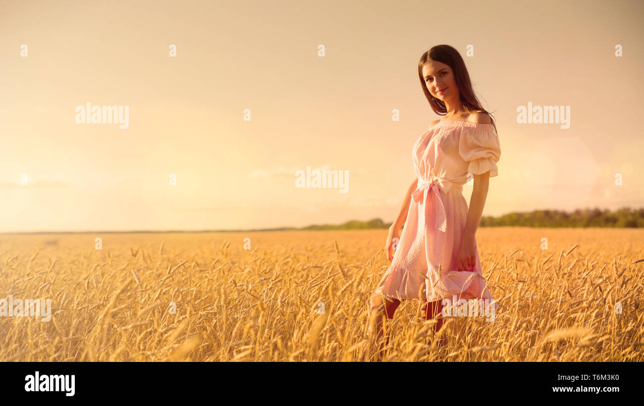 Young girl in wheat field at sunset Stock Photo - Alamy