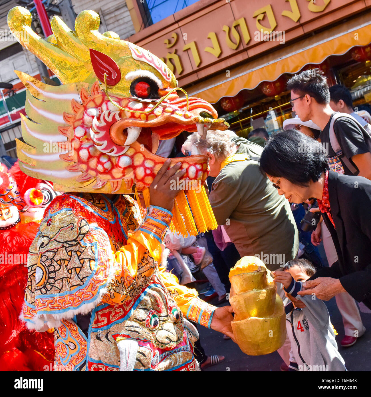 Celebration of the Chinese New Year, people donating money to the masked figures , Chiang Mai, Thailand Stock Photo