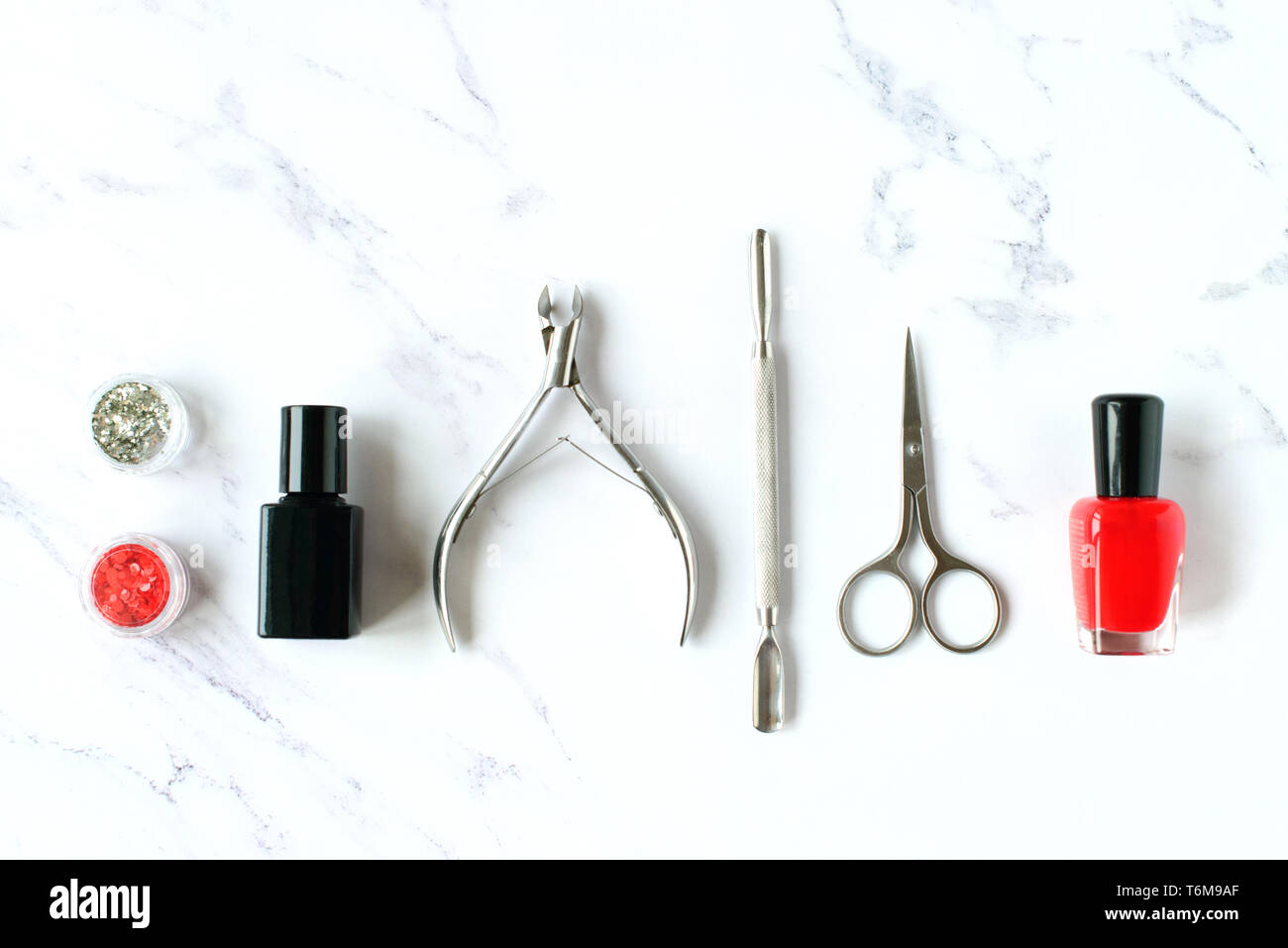 Set of various manicure and pedicure tools and accessories on white marble background. Top view. Stock Photo