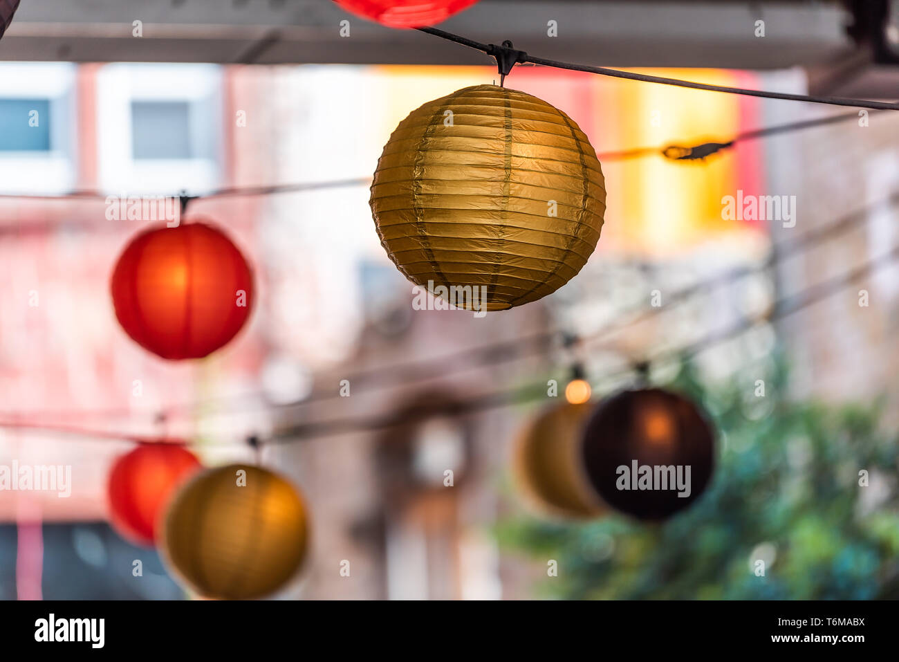 Closeup of hanging Chinese Asian paper round lanterns red and yellow colors on street outside during day Stock Photo