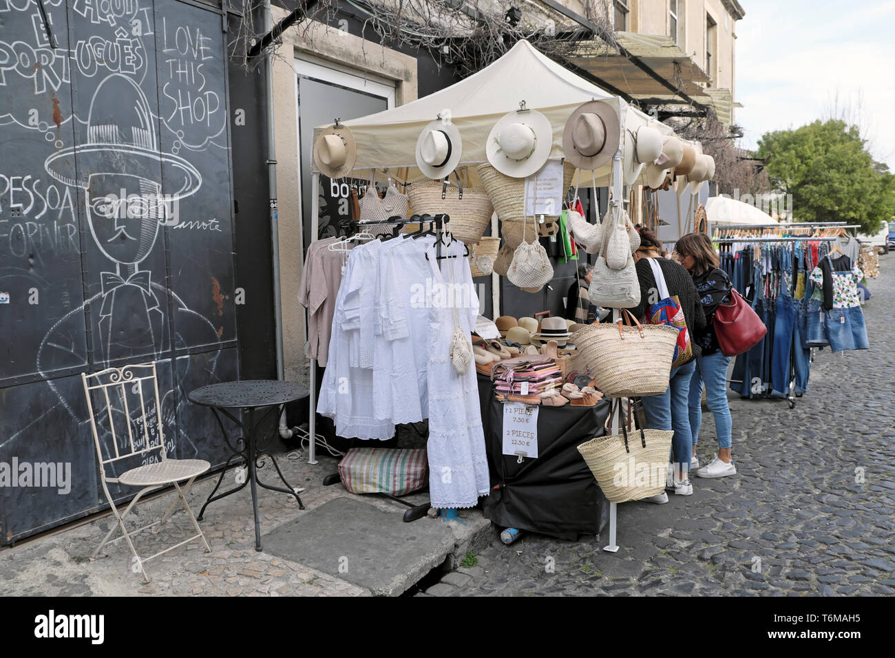 LX Factory street market selling white fashion clothing, straw hats