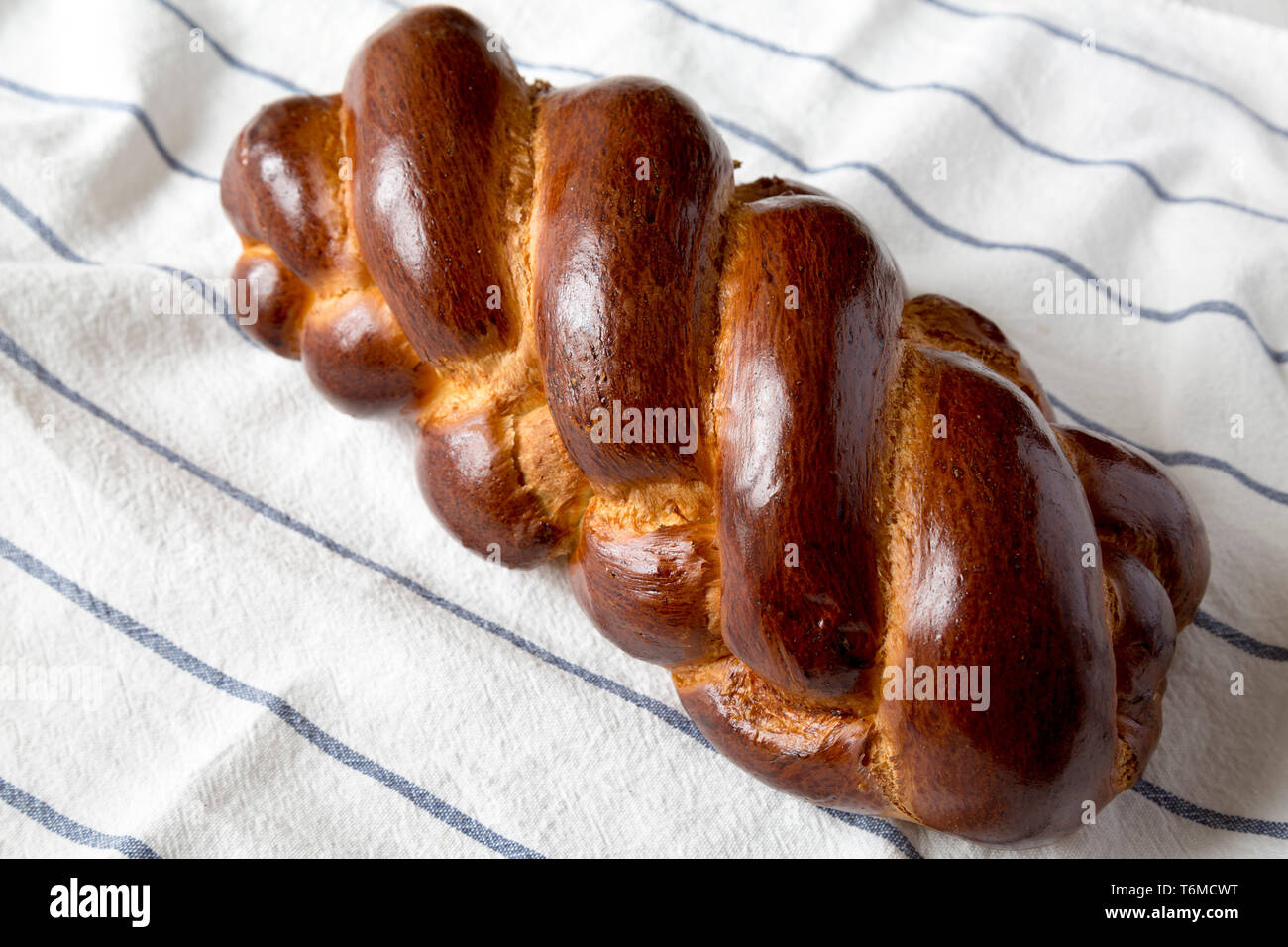 Homemade jewish challah bread on a white wooden background, side view. Stock Photo