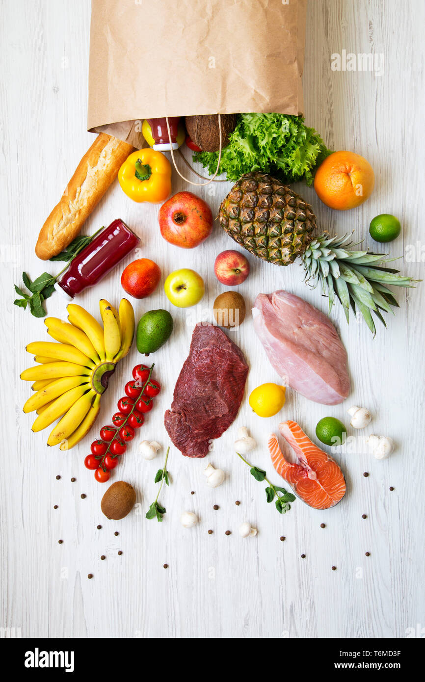 Overhead view, paper bag of different fruits and vegetables on a white ...