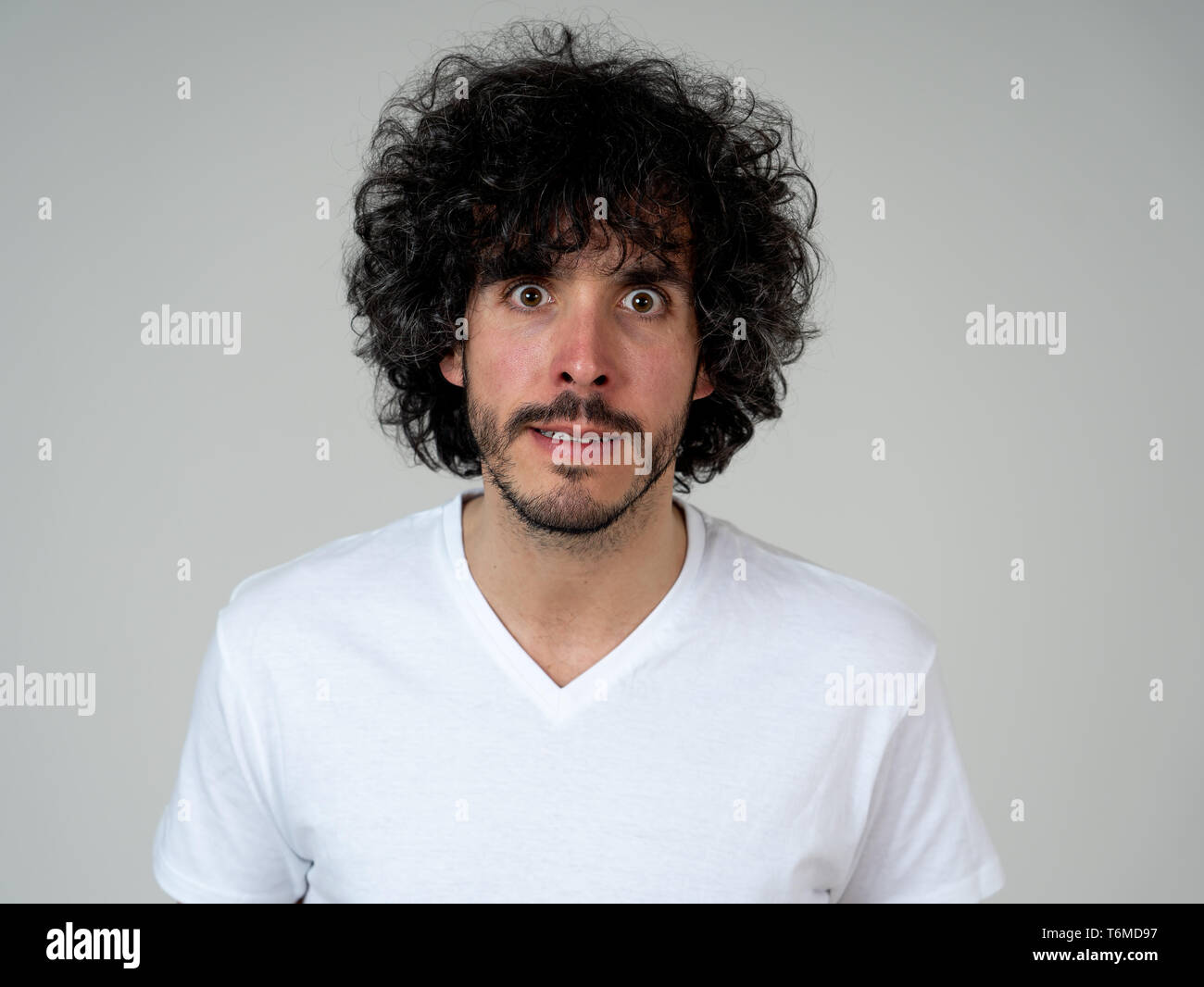 Annoyed young millennial man with an angry face looking mad and furious feeling frustrated. Close up studio shot Isolated on white background. People, Stock Photo