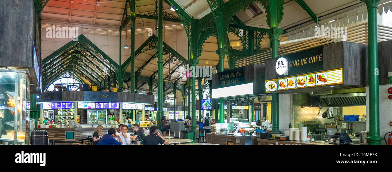 green painted cast iron latticework, and diners seated at tables Lau Pa Sat Hawker Food markets in downtown Singapore. Stock Photo