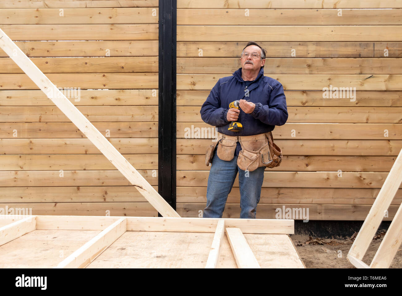 carpenter working on wood structure on residential construction Stock Photo