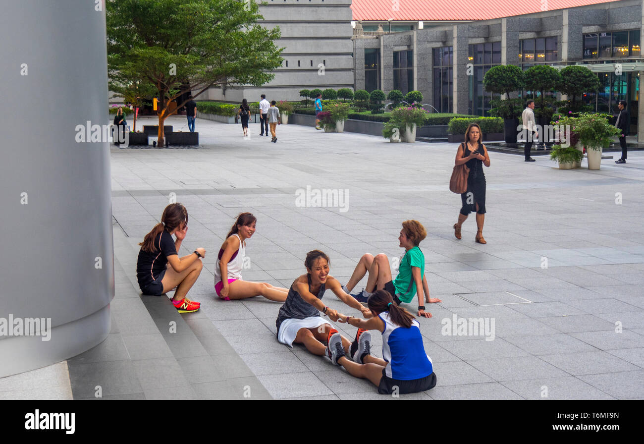Singaporean women stretching after a exercise workout in downtown Singapore. Stock Photo