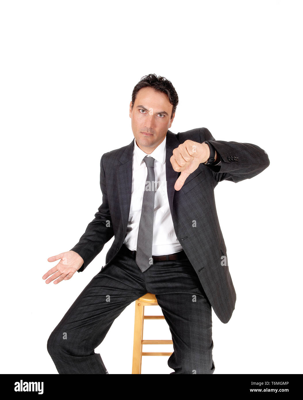 Serious looking man pointing thump down Stock Photo