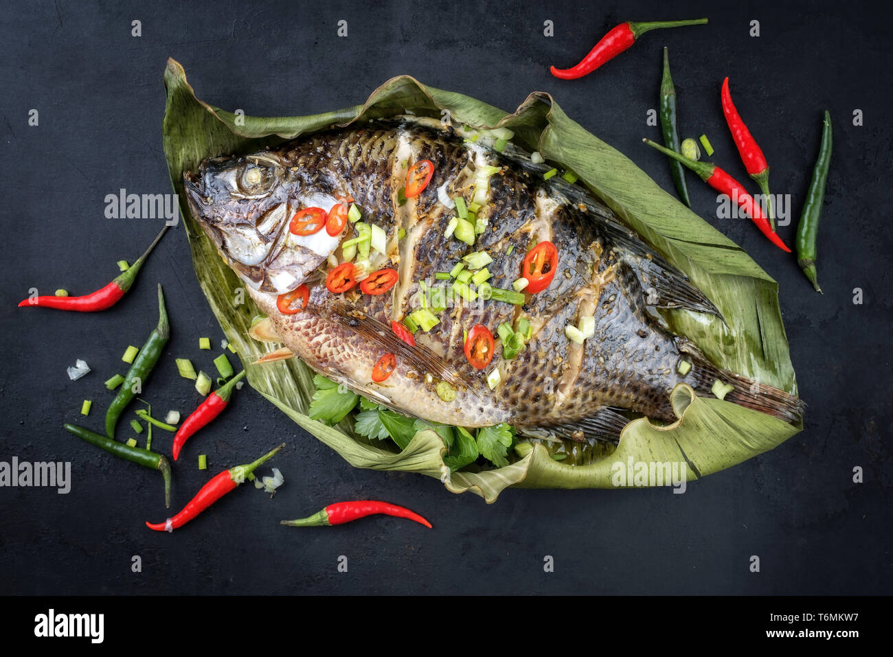 Traditional Thai barbecue tilapia fish staffed with coriander and chili
