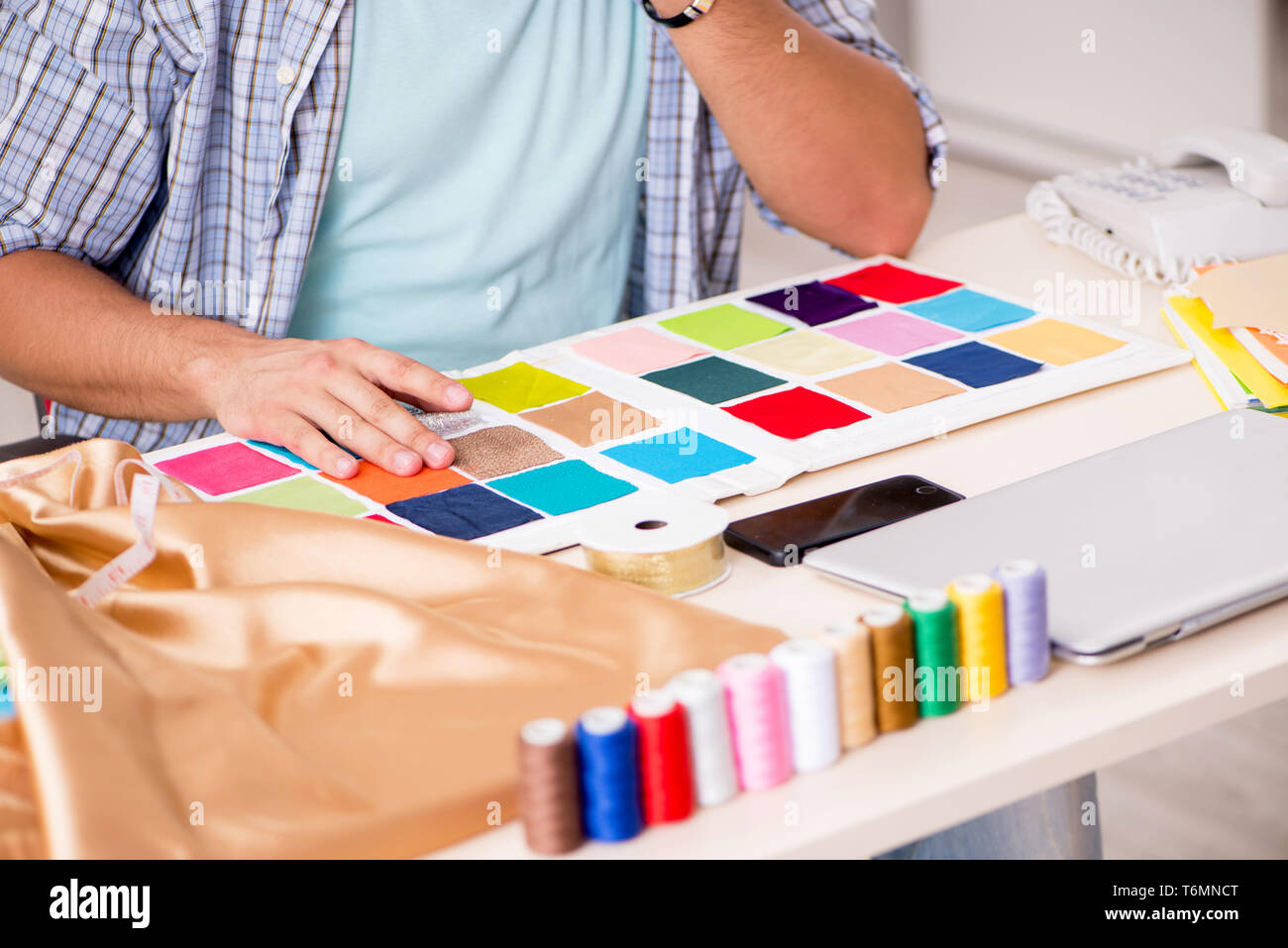 Young handsome tailor working in his workshop Stock Photo - Alamy