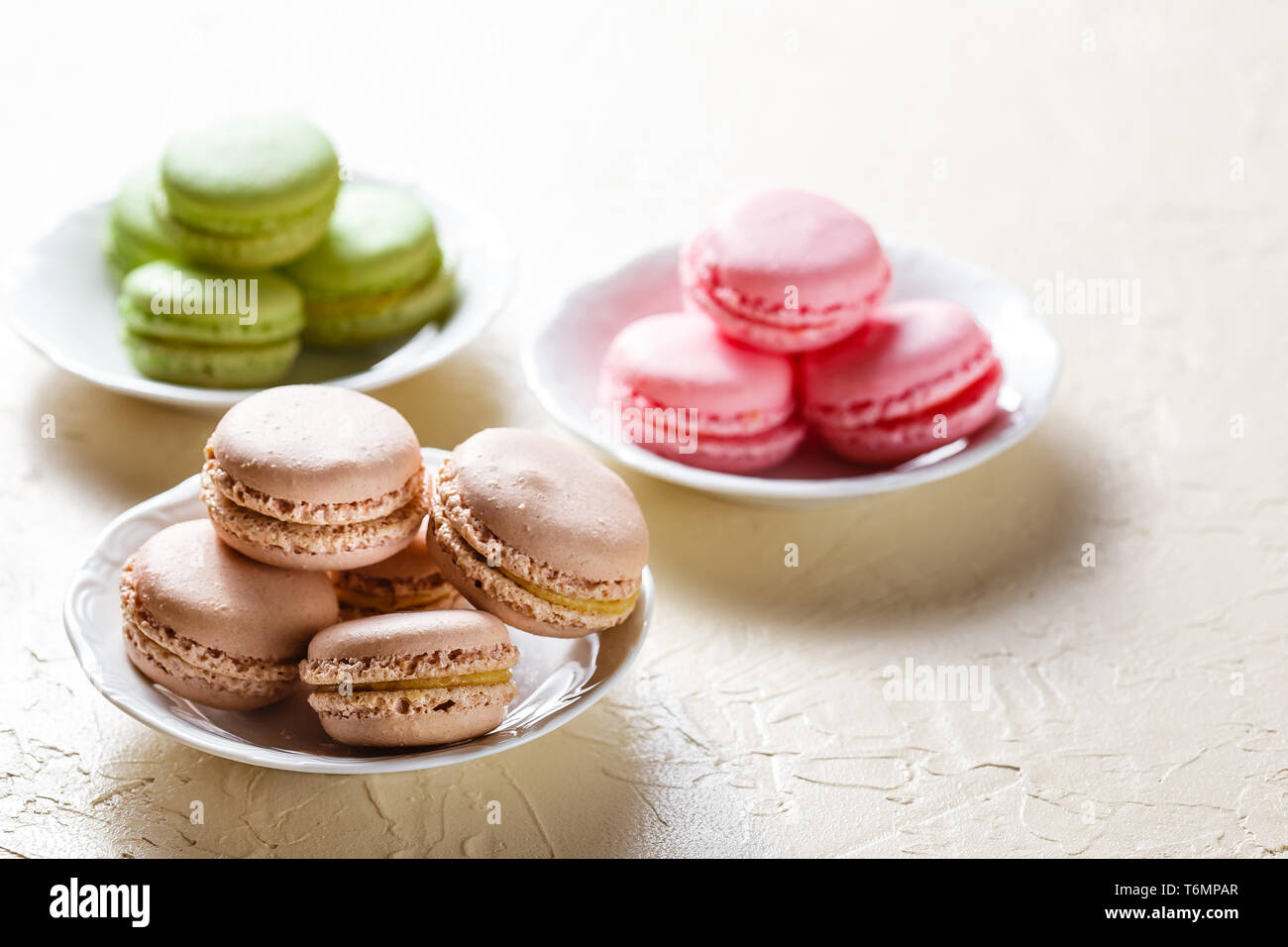 Colourful macaroons on the plates Stock Photo