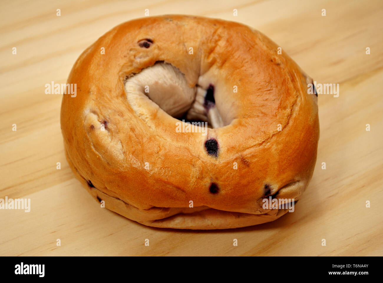 Whole Blueberry Bagel on a Wooden Surface Stock Photo