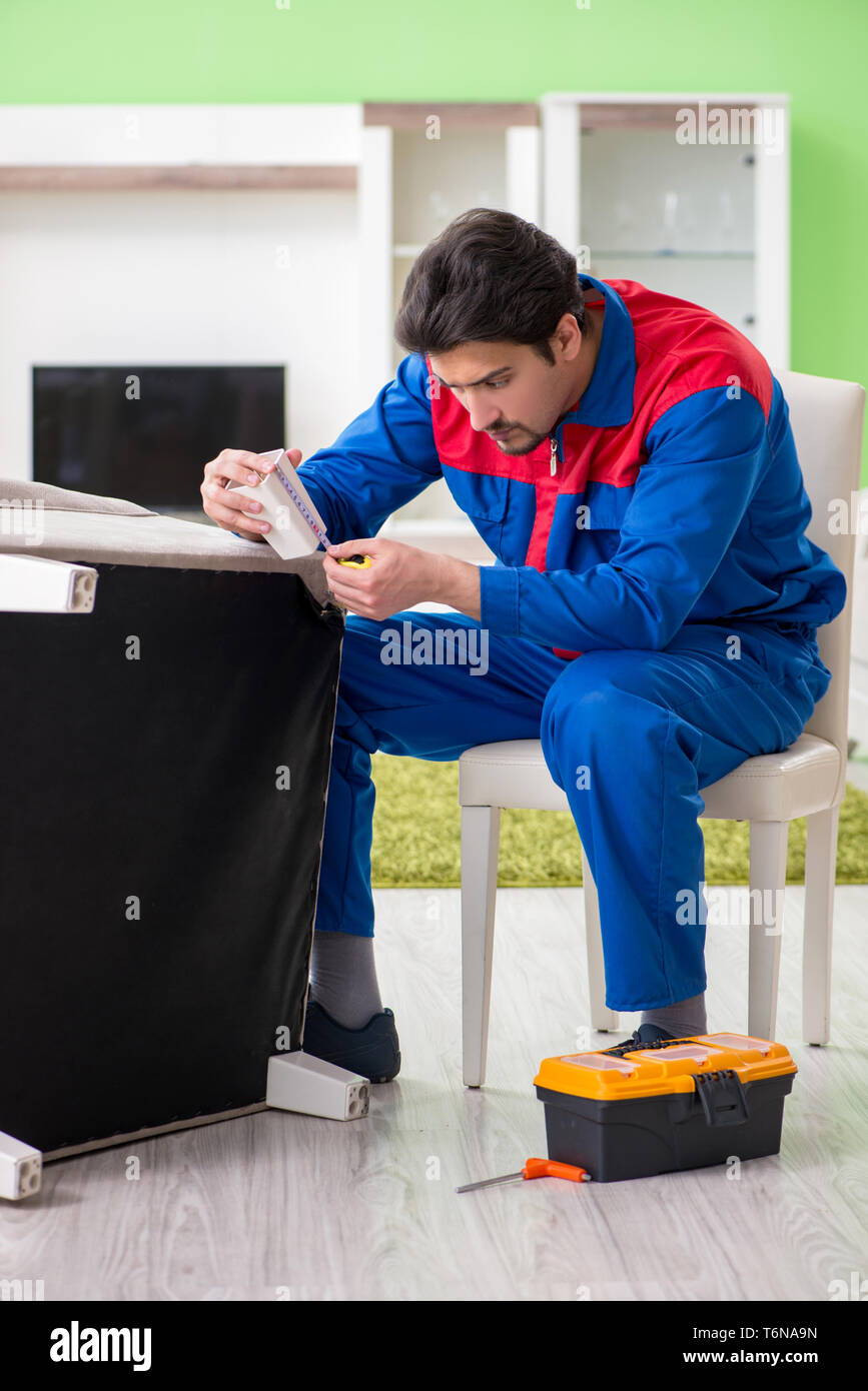 The repair contractor repairing broken furniture at home Stock Photo