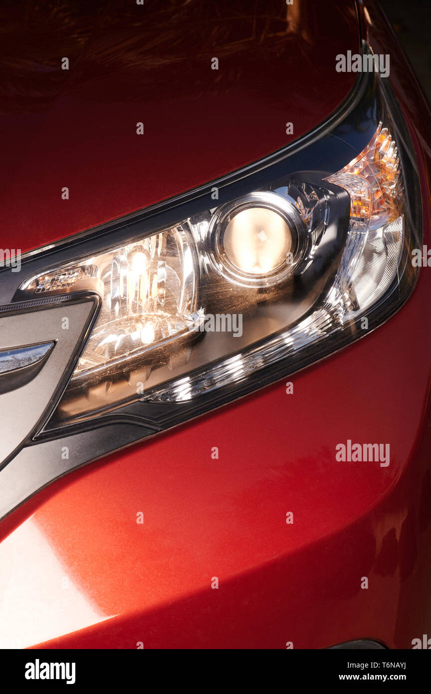 Red car headlight on with yellow lamp close up view Stock Photo