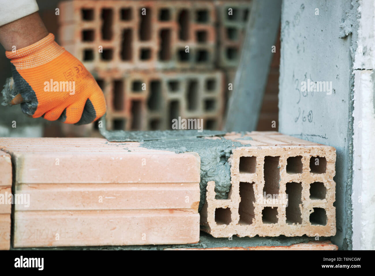 Industrial bricklayer installing bricks on construction site Stock Photo